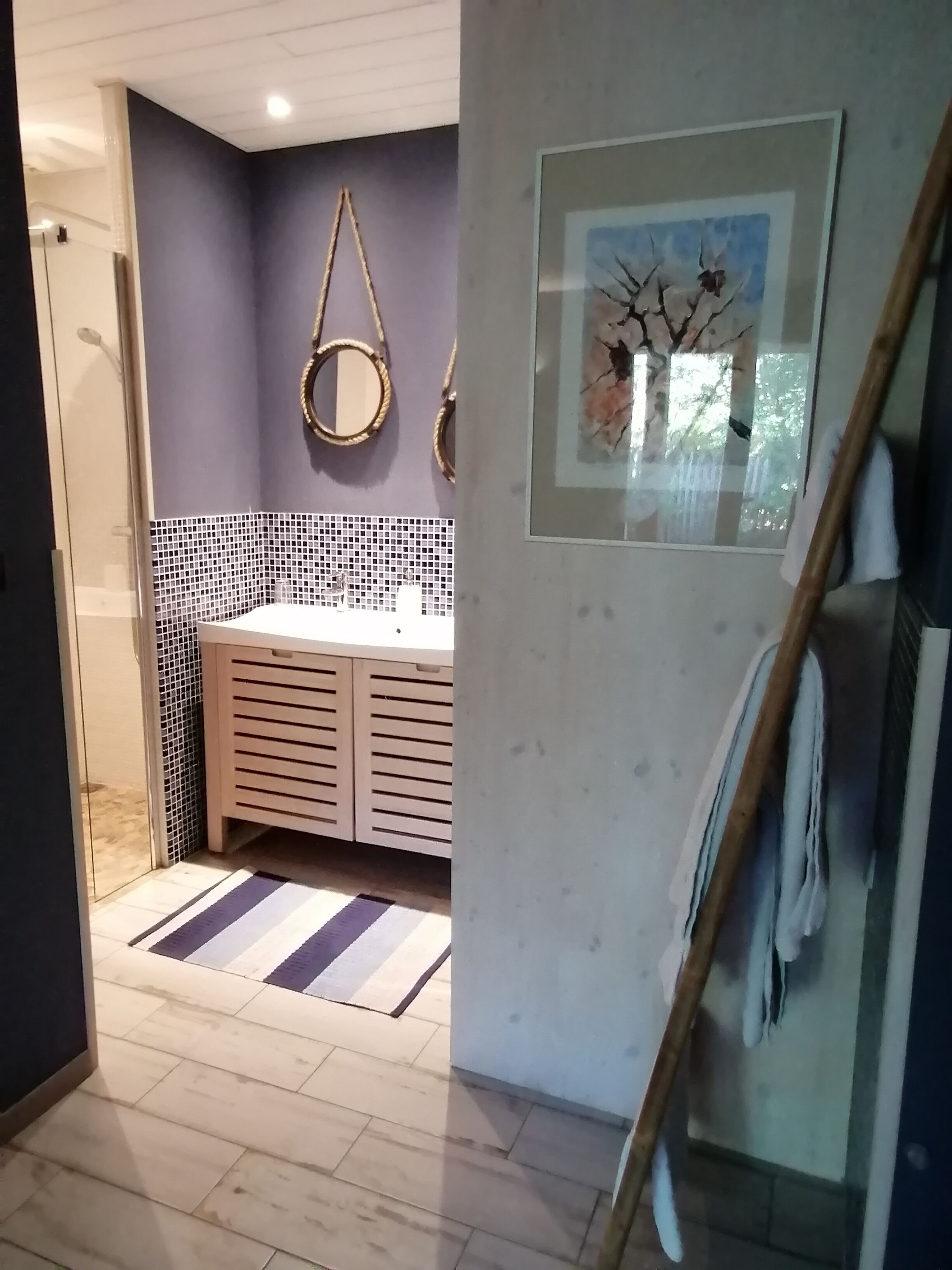 Un baño con lavamanos blanco, espejo y salpicadero de azulejos.