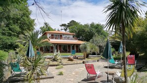 Ein Haus mit Terrasse, Sitzgelegenheit im Freien und einem Pool.