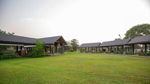 A courtyard with covered seating areas and a grassy lawn. - Waters Edge Hotel (Battaramulla)