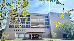 A modern building with a central entrance, multiple floors, and a parking area in front. - Waters Edge Hotel (Battaramulla)