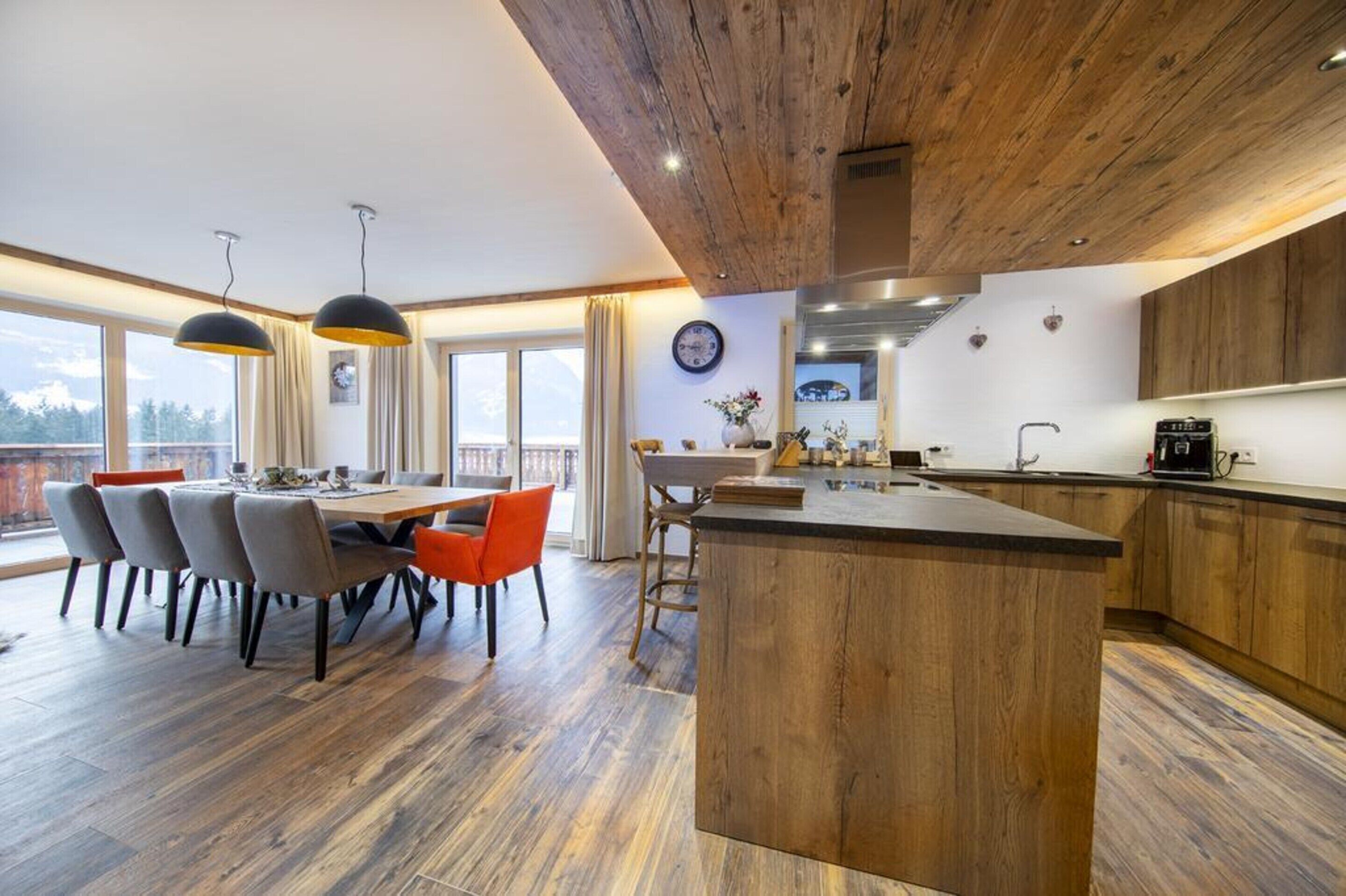 A modern kitchen with wooden cabinets, a central island, and pendant lighting.