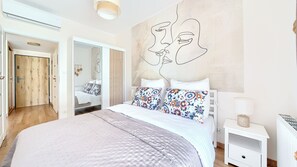 Une chambre moderne avec un grand lit, un miroir et une œuvre d’art murale.