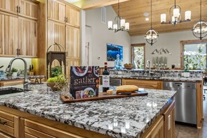 Enjoy cooking in this well-equipped kitchen with a central island and large window offering a view of the outdoors.