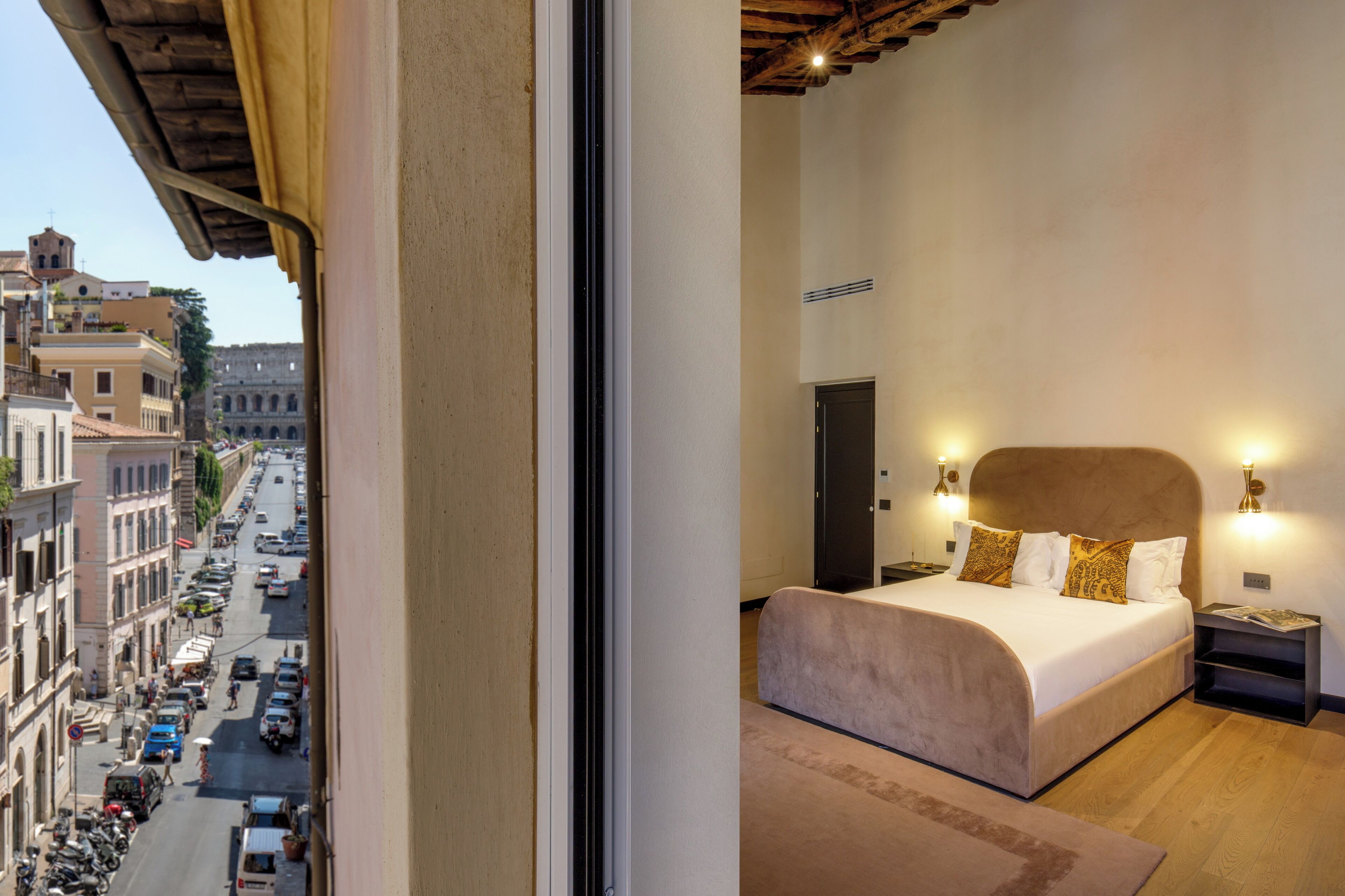 A hotel room with a large bed, a view of the city street, and a wooden ceiling.