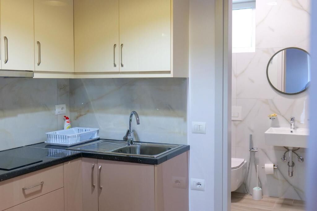 A compact kitchen with a sink, cabinets, and a countertop.