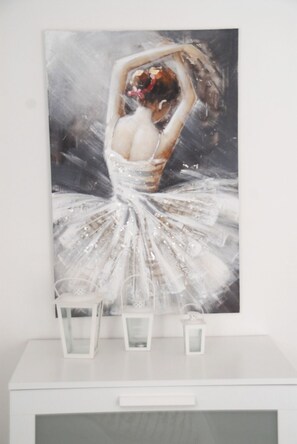 A painting of a ballerina in a tutu on a white wall.