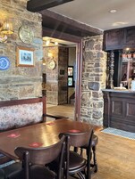 Un interior rústico con paredes de piedra, muebles de madera y una zona de bar.
