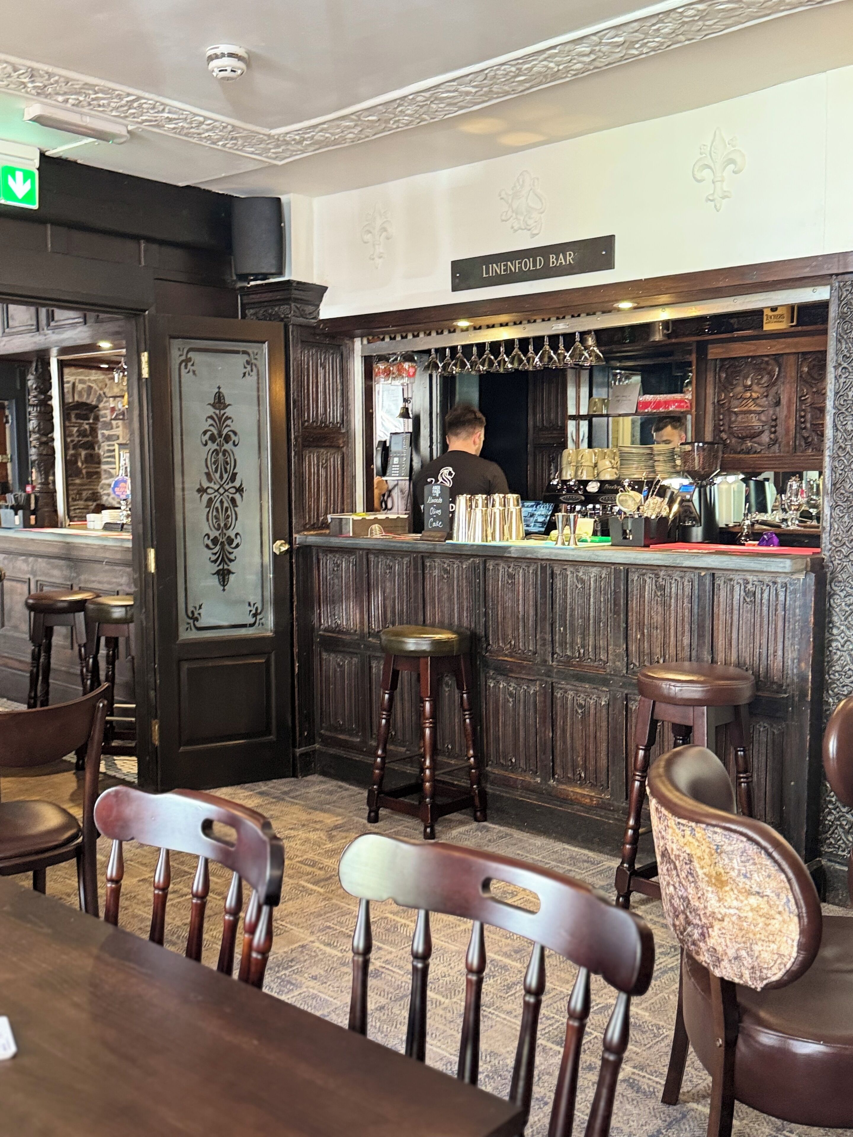 Zona de bar con taburetes de madera y una barra.