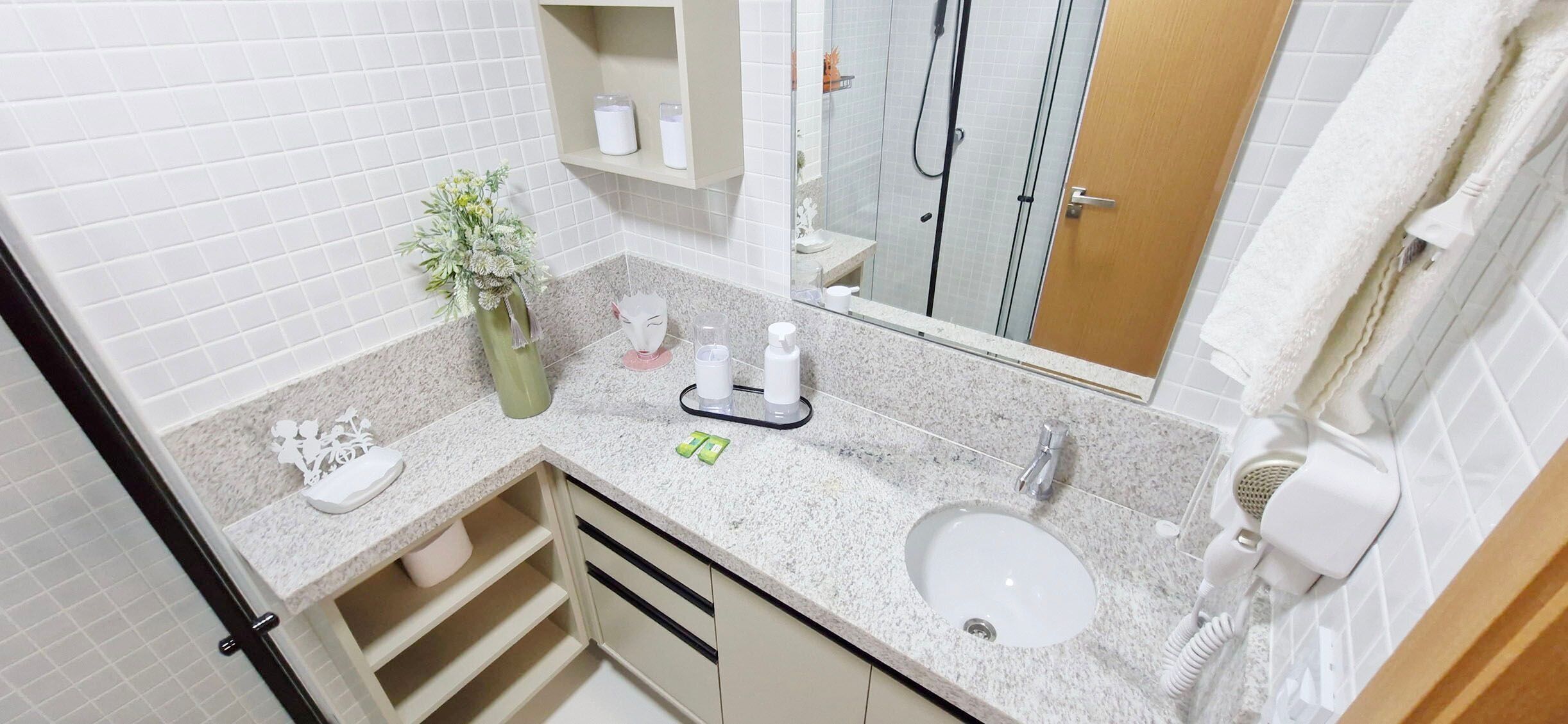 A bathroom with a white sink, a mirror, a towel rack, a shower, and a toilet.