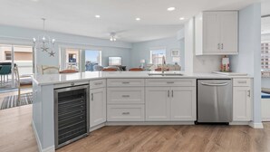 A modern kitchen with white cabinets, a built-in oven, and a dishwasher.