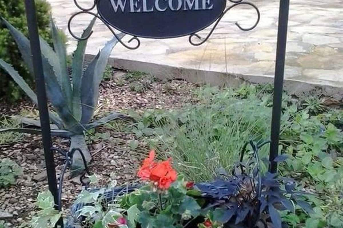 A welcome sign with a metal frame and a dark background.