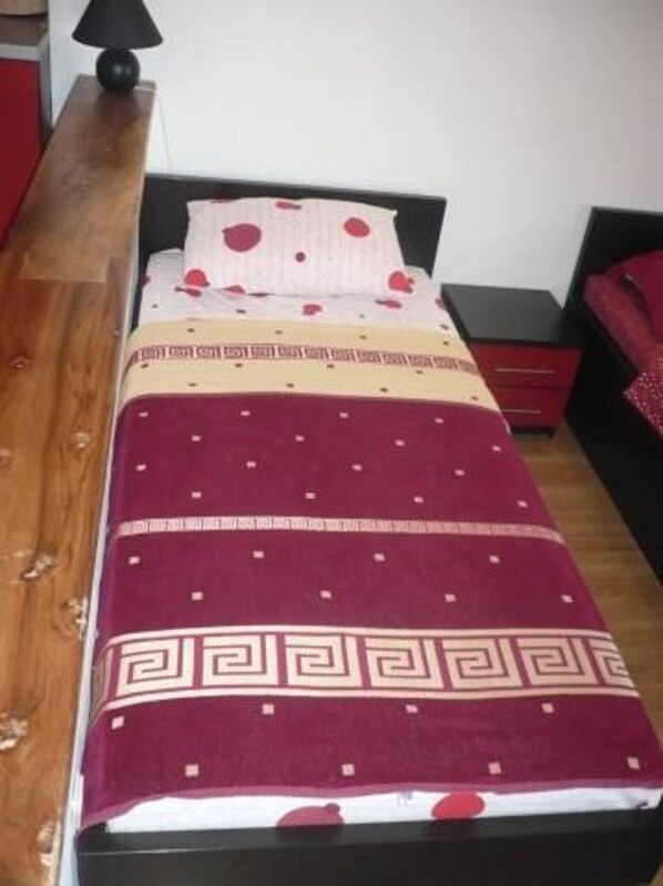 Un lit avec une couvre-lit à motifs, une table de chevet et une lampe.