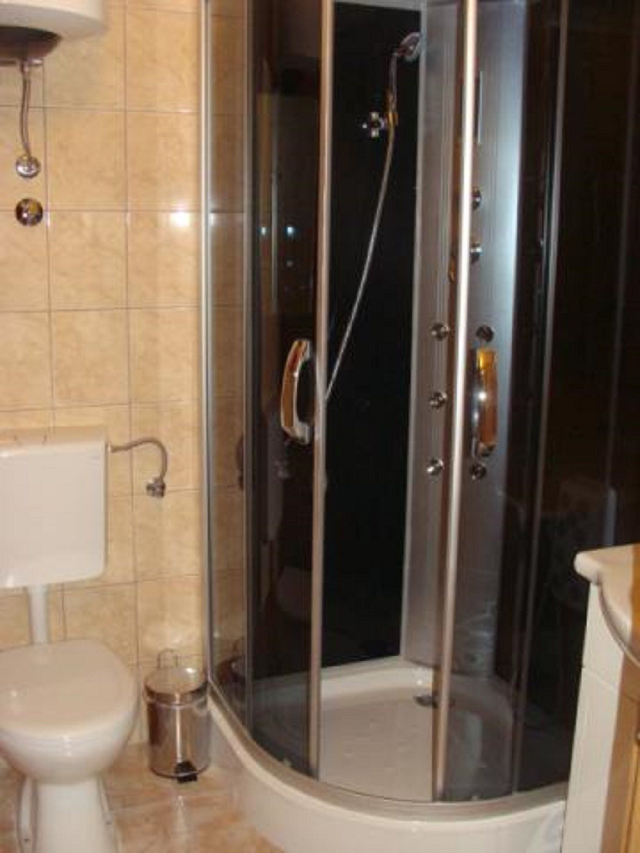 Un baño moderno con ducha de vidrio, inodoro y lavamanos.