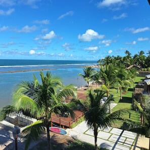 A resort with a view of the ocean, palm trees, and a beach area. - 2-Bedroom Apartment in Ipojuca - PE (Ipojuca - PE)