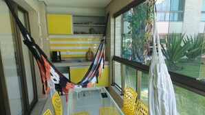 A modern kitchen with yellow cabinets, a glass table, and yellow chairs. - 2 bedroom apartment in Ipojuca - PE (Ipojuca - PE)