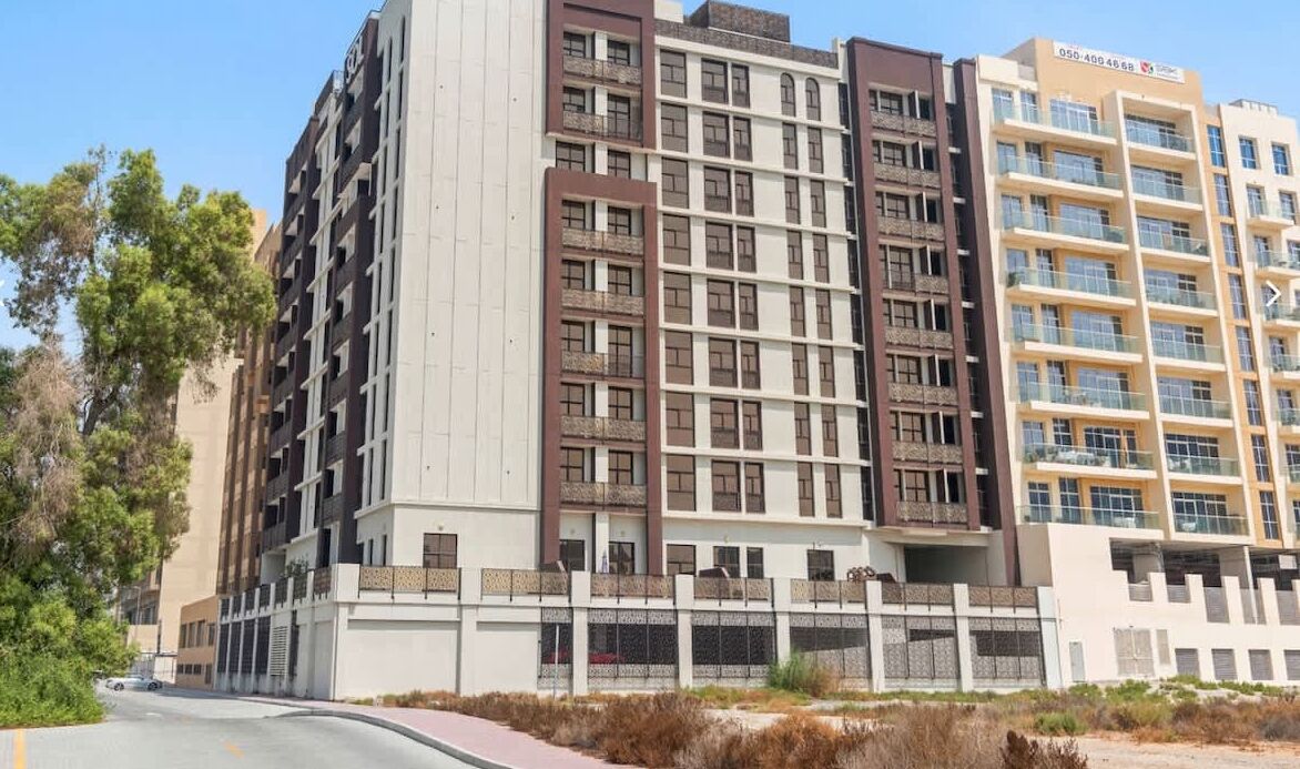 A multi-story residential building with balconies and a gated entrance.