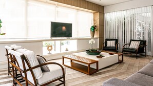 A modern living room with a sofa, chairs, a coffee table, and a TV. - 350m from Jurerê Beach | Swimming Pool #JA36 (Florianópolis)