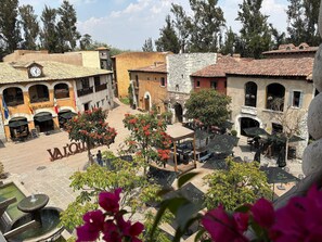 A courtyard with outdoor seating, a fountain, and a variety of buildings with different architectural styles. - Loft Michelangelo (Val'Quirico)