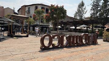 Un cortile con pavimento in pietra, posti a sedere all'aperto e un'ampia scultura in metallo.
