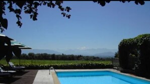 A rectangular swimming pool with a clear blue water surface, surrounded by a paved deck and a hedge. - Auberge des Chasseurs (Echenevex)