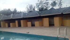 A poolside area with a long row of covered seating and a swimming pool. - Hotel Twin Towers Homa Bay (Homa Bay)