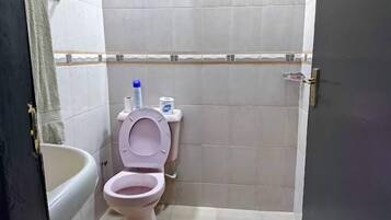 A bathroom with a toilet, a bathtub, and a towel rack.