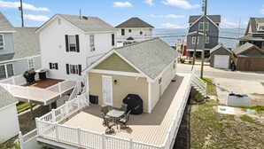A two-story house with a deck, a barbecue grill, and a small shed. - Reeds beach retreat 2 bedroom with water view (Reeds Beach)