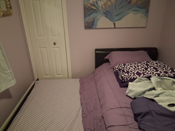 A bedroom with a bed, a door, and a painting on the wall. - Reeds beach retreat 2 bedroom with water view (Reeds Beach)