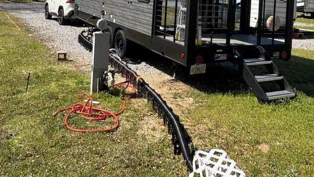A mobile home with a small porch and a garage. - Timberwolf in the Park (Pensacola)