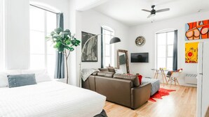 Un dormitorio moderno con una cama grande, un sofá, un escritorio y un televisor.