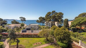 A coastal residential area with modern houses, a clear blue sky, and a view of the sea. - Beau Rivage - 7min à pied de la Plage (Carqueiranne)