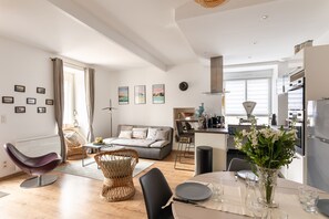 A modern apartment with a dining area, kitchen, and living room.