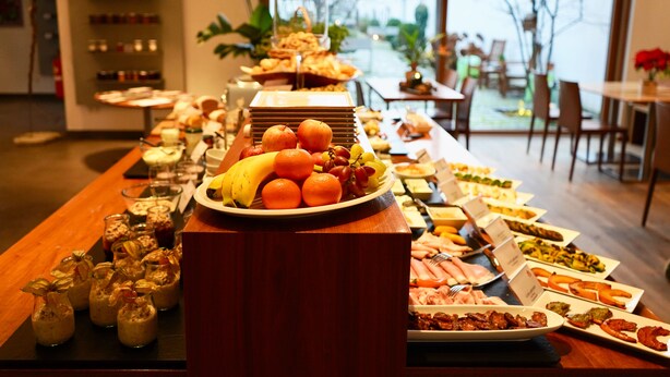 A buffet with various food items and a view of the outdoors. - Hotel Genuss am Hof (Halbturn)