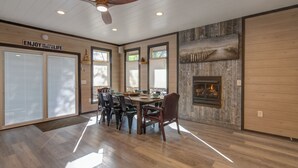 Un comedor con mesa de madera, sillas y chimenea.