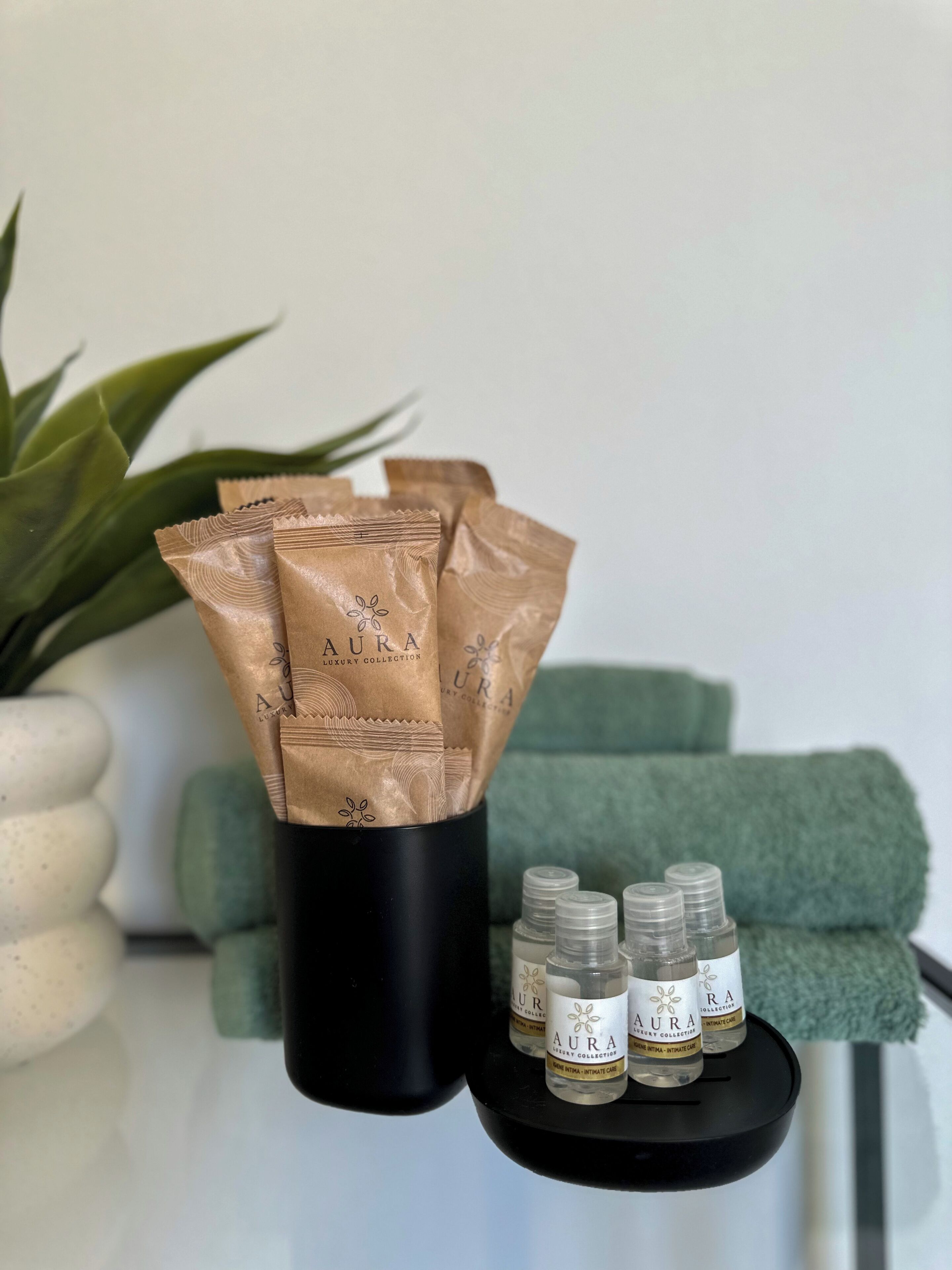 Un récipient noir contenant plusieurs sacs en papier brun et de petites bouteilles étiquetées, le tout posé sur un plateau noir.