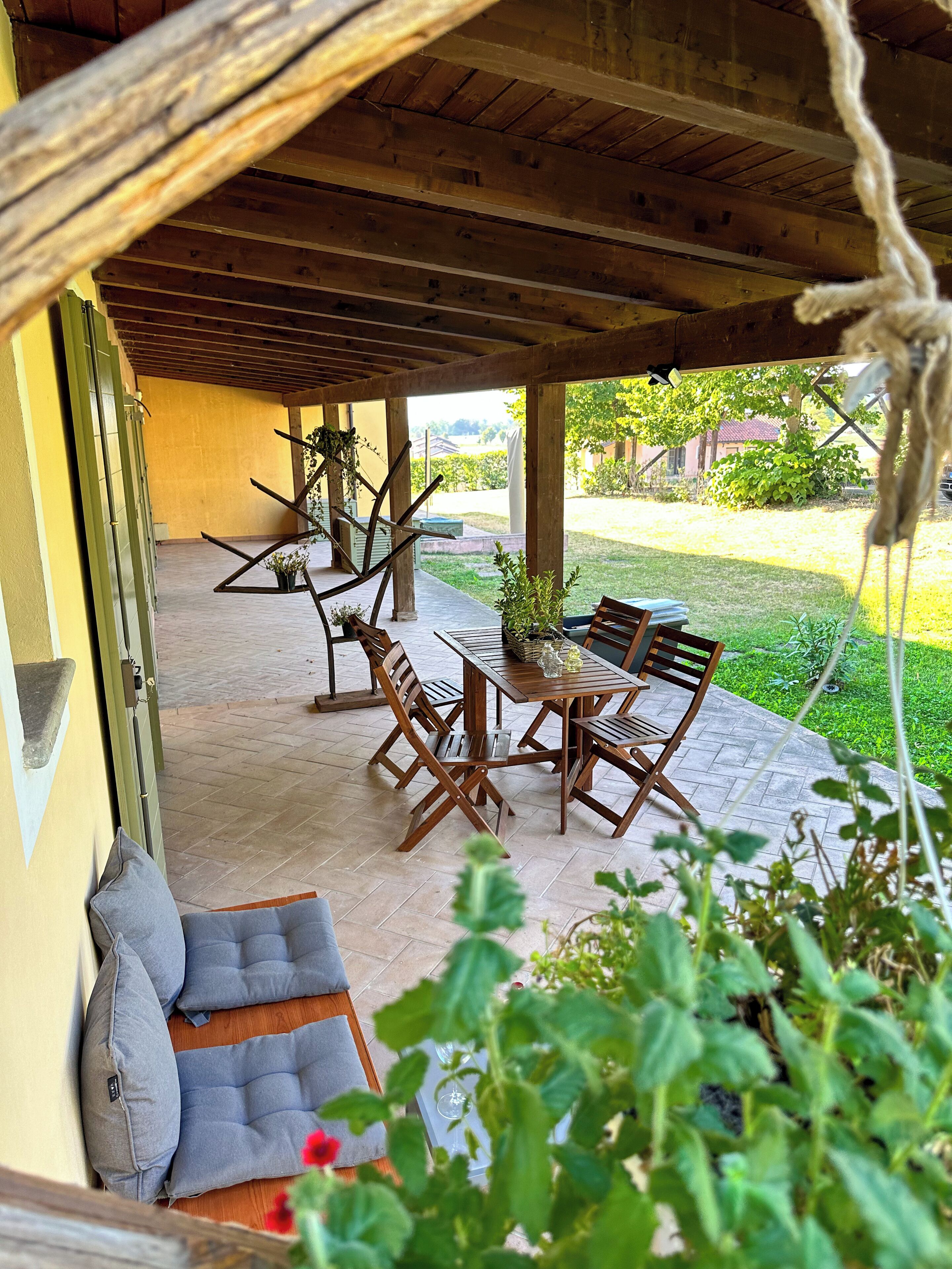 Une terrasse extérieure avec des meubles en bois, une table et des chaises.