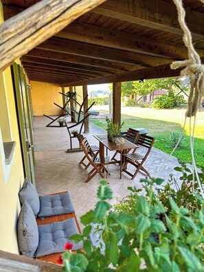 An outdoor patio with wooden furniture, a table, and chairs. - Just Langhe Casa Dolcetto (Piemonte)