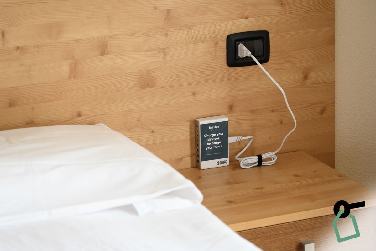 A wooden bedside table with a power outlet, a charging station, and a sign indicating a 200W charging capacity.