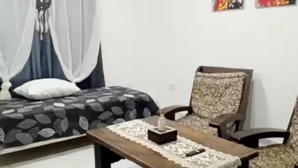Ein modernes Wohnzimmer mit einem Bett, einem Couchtisch und zwei stuhligen Sessel.