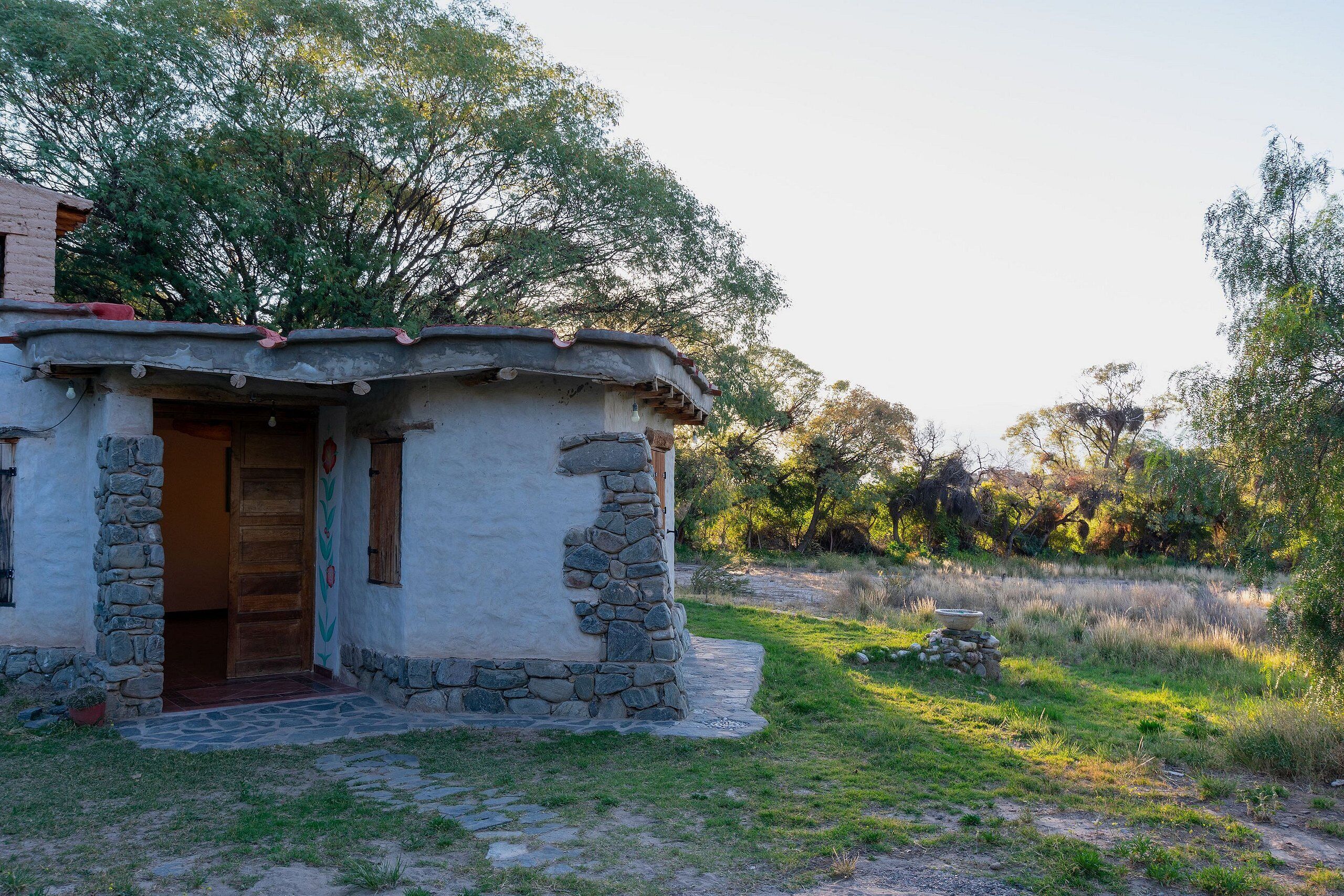 Una casa de piedra rústica con puerta de madera y un pequeño porche.