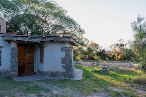 Ein rustikales Steinhaus mit einer Holztür und einer kleinen Veranda.