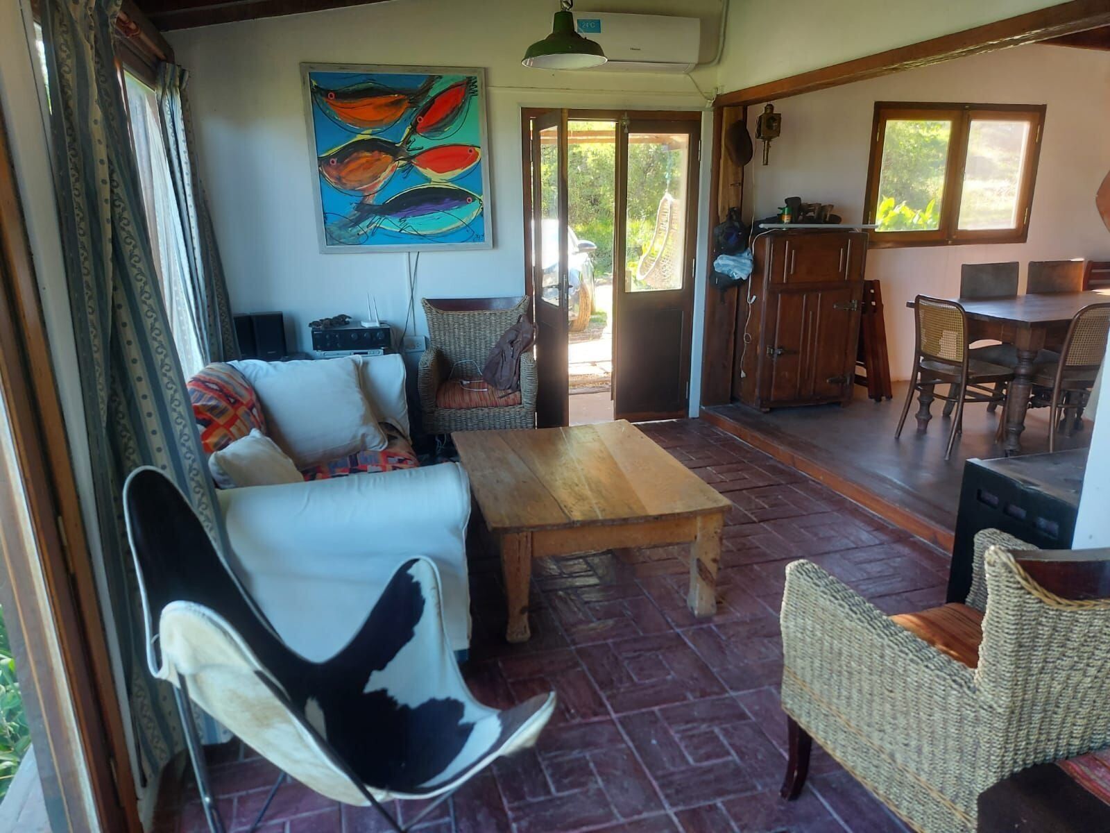 Una sala de estar con un sofá, una mesa de centro y un comedor con sillas y una mesa.