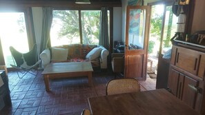 Una habitación con una mesa de madera, un sofá, una silla y un armario.
