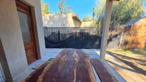 Une table de pique-nique en bois à quatre pieds, placée à l’extérieur sur un sol carrelé.