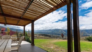 Un patio techado con vistas a montañas distantes y cielo despejado.