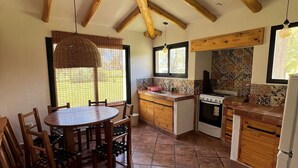 A kitchen with a dining table, chairs, a stove, and a refrigerator.