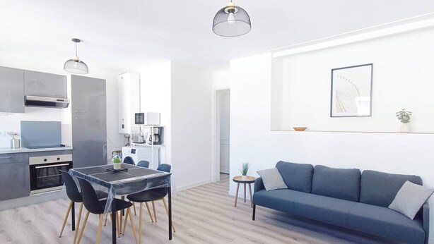 Un espacio habitable moderno con comedor, kitchenette y sofá.