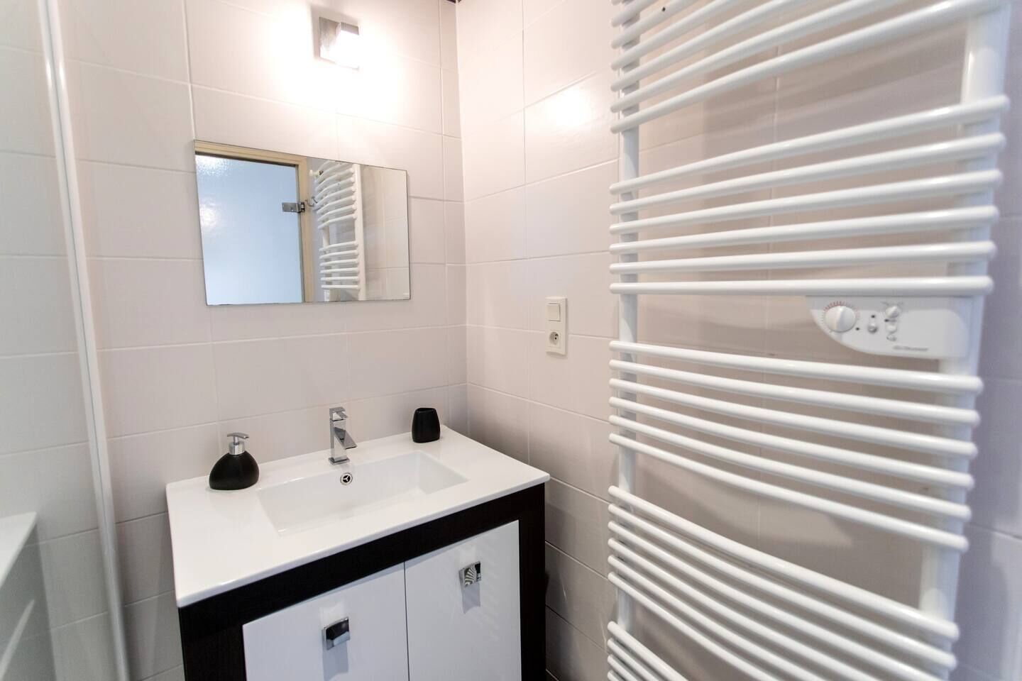 Ein modernes Badezimmer mit Waschbecken, Spiegel und Handtuchhalter.