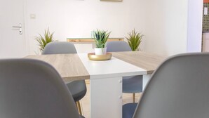 Un comedor moderno con una mesa de madera, dos sillas y una planta en maceta sobre la mesa.