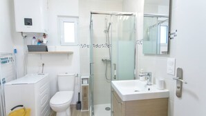 A modern bathroom with a toilet, sink, and shower. - Studio Le Brivet City Center ☆ Parking ☆ Terrace (Pontchâteau)